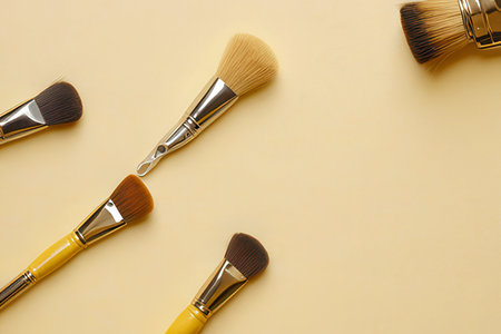Set of makeup brushes on beige background. Flat lay, top view.の素材