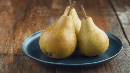Ripe pears on a blue plate on a wooden background.の素材
