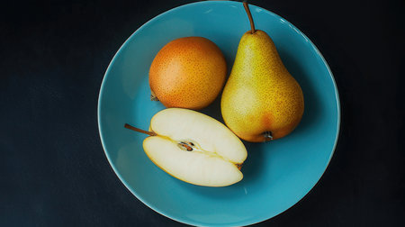 Ripe pears on a blue plate on a black background.の素材