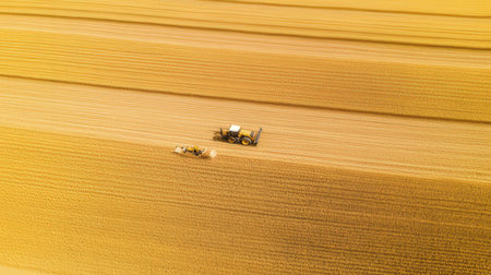 Aerial view on the tractor working on the large wheat field.の素材