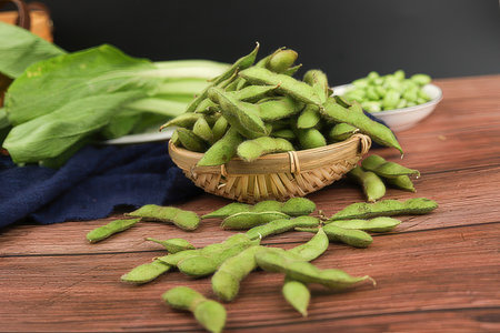 Edamame, green soybeans in a basket on wooden backgroundの素材