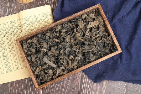 Dry black tea leaves in a wooden box, top view.の素材