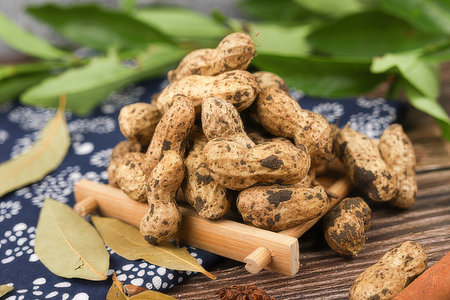 peanuts in a wooden bowl on a wooden table, close-upの素材