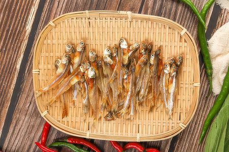 Dried fish on bamboo sieve on wooden background. Top viewの素材