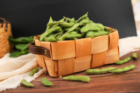 Green soybeans in a basket on a wooden background. Healthy food.の素材