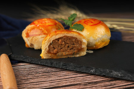 Baked buns with meat and cheese on a dark background.の素材