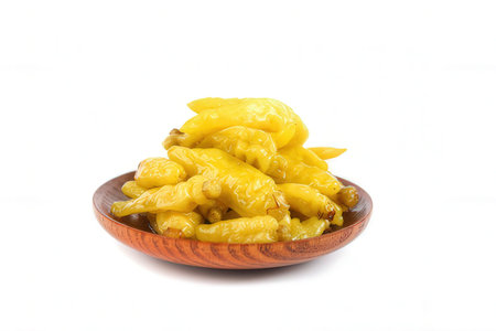 Pickled yellow peppers in a wooden bowl isolated on white background.の素材