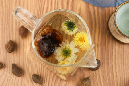Top view of herbal tea with wild flowers in glass cup on wooden tableの素材