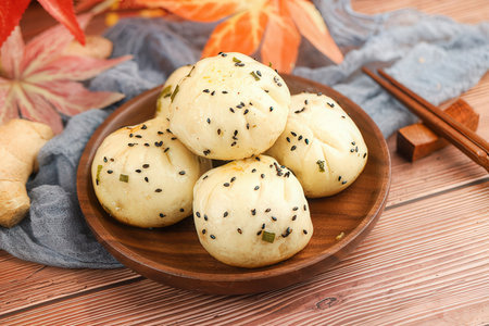 Bread buns with sesame seeds on a wooden plate.の素材