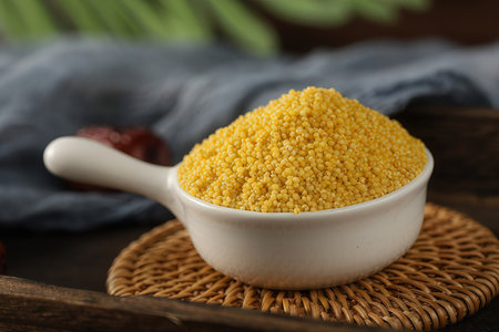 Raw millet in a bowl on a wooden table, closeupの素材