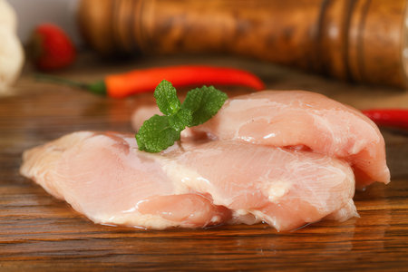 Raw chicken fillet on wooden cutting board, closeup. Healthy foodの素材