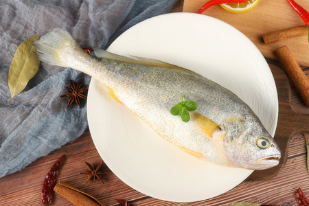 Fresh dorado fish on plate, on wooden table, top viewの素材