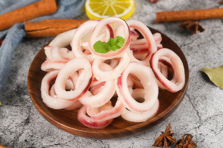 Marinated squid rings with lemon and spices on gray background, closeupの素材