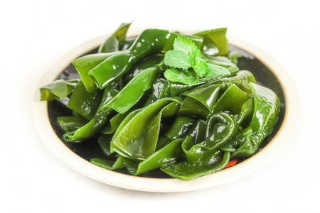 Stir-fried green chillies on a plate, isolated on white backgroundの素材