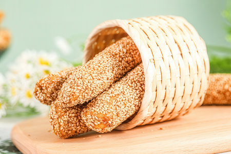 Bread sticks with sesame seeds in a wicker basket.の素材