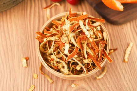 Dried orange slices in a bowl on a wooden table, close upの素材