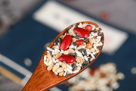 Close up of a wooden spoon full of seeds and nutsの素材