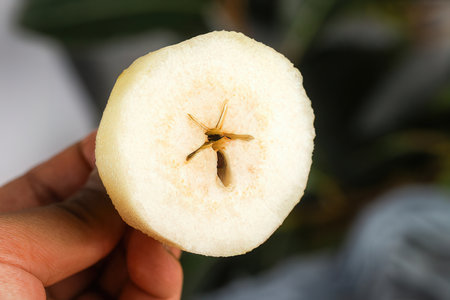 Sliced banana in hand on blurred background, close up viewの素材
