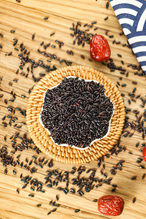 Rice berry in a bowl on a wooden background, top viewの素材