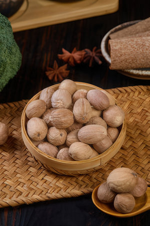 Nuts in a bamboo bowl on a dark wooden background.の素材
