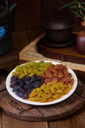 Dried fruits in a plate on a wooden table in the kitchenの素材