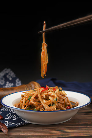 Stir-fried spaghetti with chili pepper in white bowl on wooden tableの素材