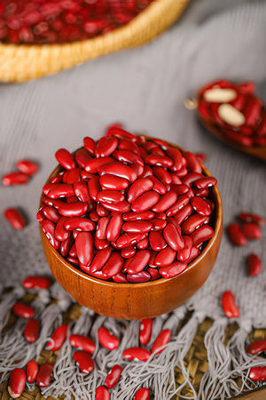 Red kidney beans in wooden bowl on wooden background. Selective focus.の素材
