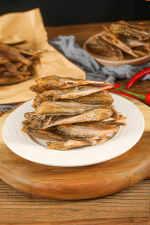 Dried fish on a white plate on a wooden table. Close-up.の素材