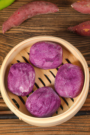 Sweet potato in bamboo basket on wooden background, sweet potatoの素材