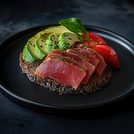 Sandwich with tuna, avocado and tomato on a black background.の素材