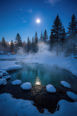 Beautiful winter landscape with hot spring in the forest and moonlightの素材