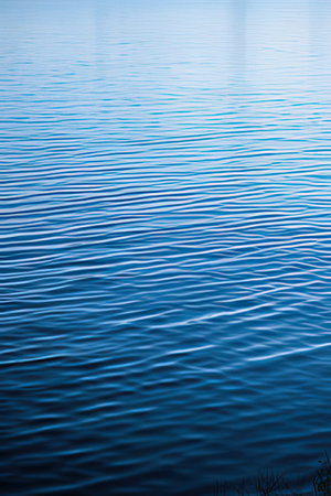blue water background with some smooth ripples and some reflections in itの素材
