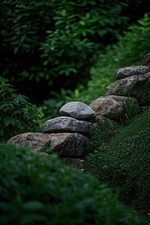 Stone wall in the garden with green grass and trees in the backgroundの素材