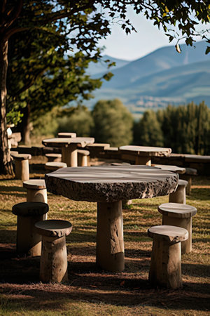 Wooden table and chairs in the park with mountains on the backgroundの素材