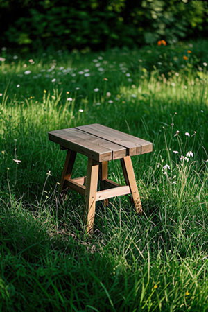 Wooden stool on the grass in the garden. Selective focus.の素材