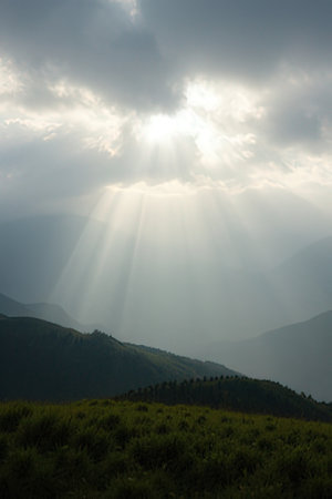 Mountain landscape with sunbeams and clouds on the sky.の素材