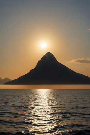 Sunset over a mountain in the sea with waves and reflection.の素材