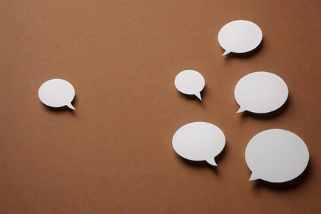 White paper speech bubbles on brown background. Copy space for text.の素材