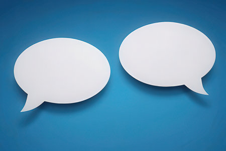 Two white speech bubbles on blue background. 3d render illustration.の素材