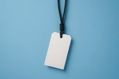 Blank price tag with rope on blue background. Top view.