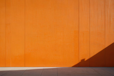 Orange wall with shadow on the concrete floor. Architectural background.の写真素材