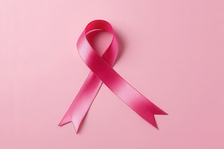 Pink ribbon on pink background. Breast cancer awareness concept. Copy space.の写真素材