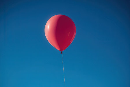 Red balloon on the blue sky background. Space for your text.