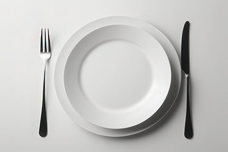 Empty plate, knife and fork on white background. Top view.の写真素材