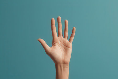 Female hand showing five fingers on blue background with copy space, close upの写真素材
