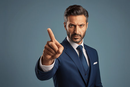 Serious mature businessman in blue suit pointing at camera with index fingerのeditorial素材