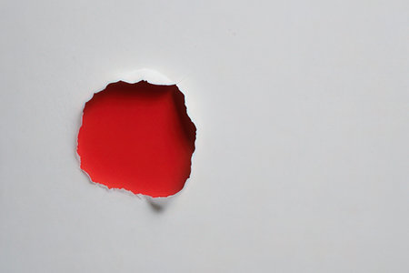 White paper hole in the middle with red background, space for textの写真素材