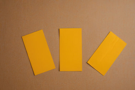 Yellow business cards on a brown background. Top view. Copy space.の写真素材