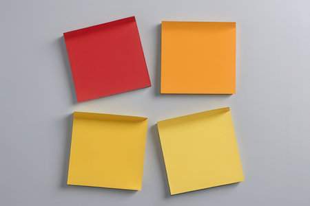 Red, yellow and orange sticky notes on a gray background with copy space