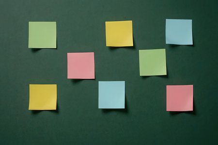 Colorful sticky notes on a green background with space for text.の写真素材